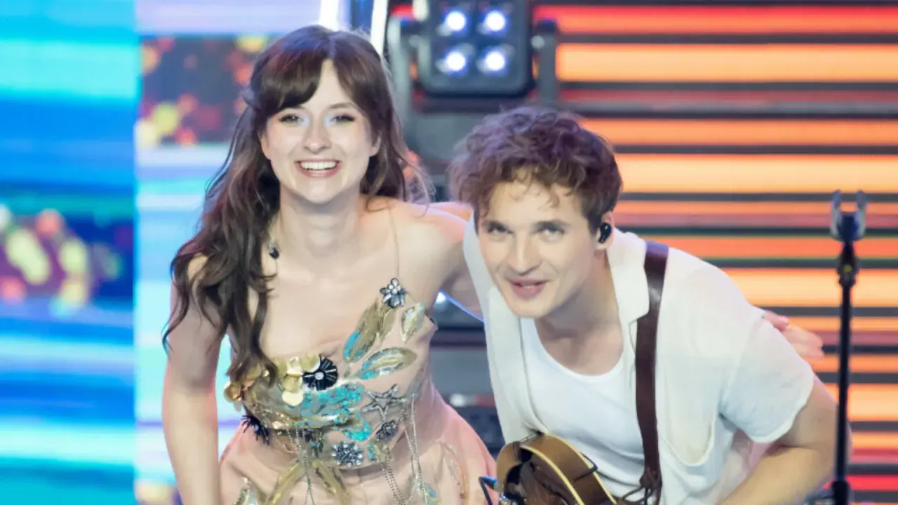 Kto śpiewa Kwiat Jabłoni? To młoda para artystów na scenie, ona w ozdobnej sukni, on z gitarą.