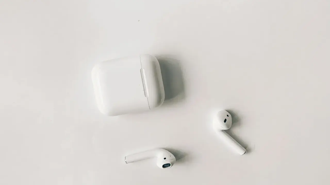 Białe słuchawki AirPods i etui na białym tle. Czy airpods działają z androidem? Tak, można je sparować.