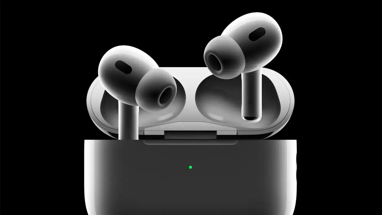 Białe słuchawki AirPods Pro w etui z zieloną diodą, na czarnym tle.