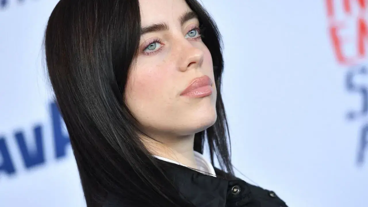 Billie Eilish z błękitnymi oczami i czarnymi włosami. Zastanawiasz się, ile kosztuje bilet na koncert Billie Eilish?