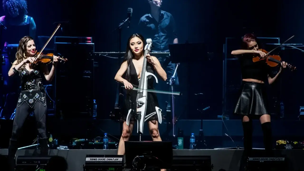 Trzy artystki grają na instrumentach smyczkowych podczas koncertu. Zastanawiasz się, ile trwa koncert Hansa Zimmera?