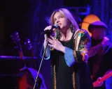 Anna Dąbrowska śpiewa na scenie. Koncert trwa, a fani zastanawiają się, ile trwa koncert Ani Dąbrowskiej.
