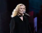 Kto śpiewa piosenkę w filmie Kogel Mogel? To ona, z mikrofonem w dłoni, na scenie.