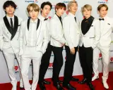 Siedmiu członków BTS w białych garniturach na czerwonym dywanie. Zastanawiasz się, ile kosztuje bilet na koncert BTS?