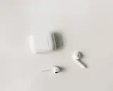 Białe słuchawki AirPods i etui na białym tle. Czy airpods działają z androidem? Tak, można je sparować.