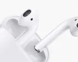 Białe słuchawki AirPods w etui. Dowiedz się, jak sprawdzić ile AirPods mają baterii, by zawsze cieszyć się muzyką.
