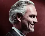 Uśmiechnięty Andrea Bocelli w garniturze. Zastanawiasz się, ile trwa koncert Andrea Bocelli?