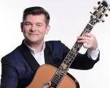 Uśmiechnięty Zenek Martyniuk z gitarą. Dowiedz się, gdzie najbliższy koncert Zenka Martyniuka i baw się świetnie!
