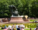 Koncert chopinowski w Łazienkach Królewskich. Tłumy słuchają muzyki przy pomniku Chopina.