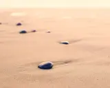 Spacer dzika plaża. Kamienie na piasku, szum fal. Kto śpiewa? Może wiatr?