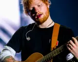 Ed Sheeran gra na gitarze, a jego wiek to 33 lata.