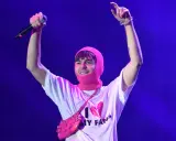 Mata z mikrofonem i różową kominiarką na głowie, w koszulce "I ❤️ MY FANS". Fani zastanawiają się, ile trwają koncerty Maty.