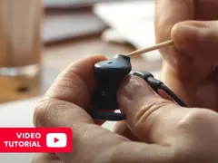 Ręce czyszczą słuchawki douszne wykałaczką. Dowiedz się, jak wyczyścić słuchawki douszne, oglądając ten tutorial.