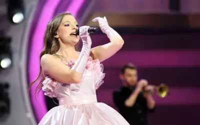 Sanah w różowej sukni śpiewa na koncercie w Łodzi. Czy wiesz, ile trwa koncert sanah łódź?