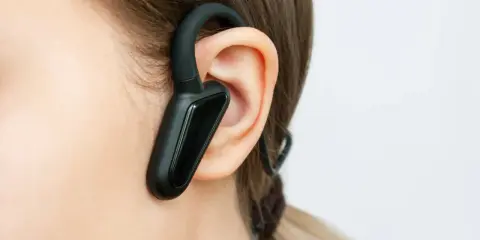 Czarna słuchawka bluetooth na uchu, idealna do rozmów w biegu.