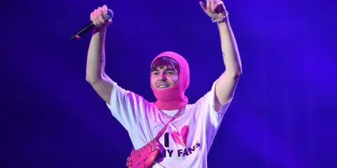 Mata z mikrofonem i różową kominiarką na głowie, w koszulce "I ❤️ MY FANS". Fani zastanawiają się, ile trwają koncerty Maty.