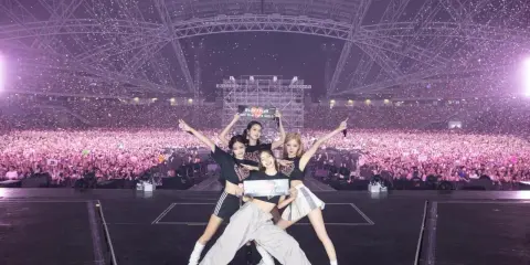 Cztery członkinie BLACKPINK pozują na scenie przed tłumem fanów. Zastanawiasz się, ile kosztuje bilet na koncert BLACKPINK?