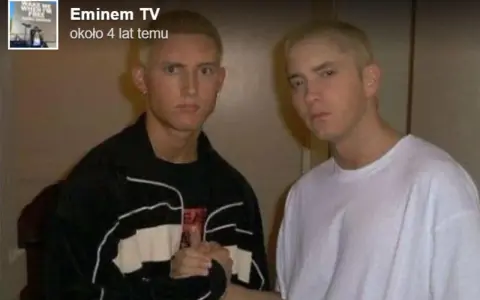 Dwóch młodych mężczyzn, jeden w czarnej bluzie, drugi w białej koszulce, pozuje do zdjęcia. Czy eminem żyje? Tak, ten artysta ma się dobrze.