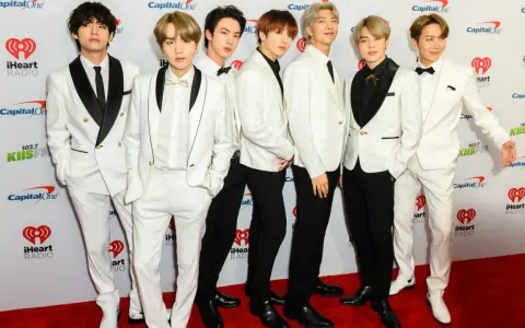 Siedmiu członków BTS w białych garniturach na czerwonym dywanie. Zastanawiasz się, ile kosztuje bilet na koncert BTS?