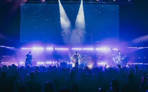 Zespół 4dreamers gra na scenie, a tłum szaleje. Koncert trwa, a fani śpiewają razem z artystami.