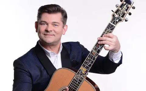 Uśmiechnięty Zenek Martyniuk z gitarą. Dowiedz się, gdzie najbliższy koncert Zenka Martyniuka i baw się świetnie!