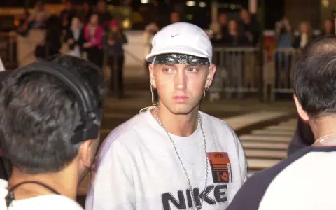 Eminem w białej czapce i z łańcuchami na szyi. Zastanawiasz się, ile Eminem ma piosenek?