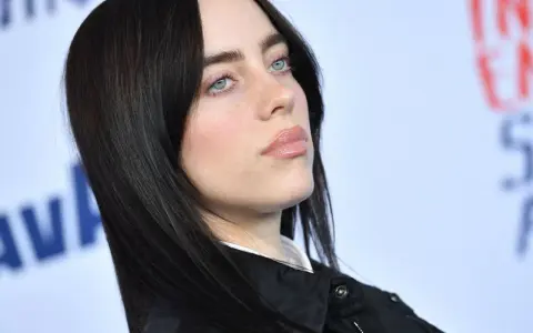 Billie Eilish z błękitnymi oczami i czarnymi włosami. Zastanawiasz się, ile kosztuje bilet na koncert Billie Eilish?