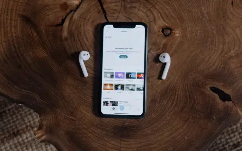 Telefon z aplikacją "Explore" i słuchawki AirPods leżące na drewnianym blacie. Dowiedz się, jak podłączyć AirPods do telefonu.