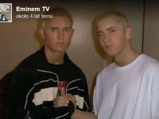 Dwóch młodych mężczyzn, jeden w czarnej bluzie, drugi w białej koszulce, pozuje do zdjęcia. Czy eminem żyje? Tak, ten artysta ma się dobrze.