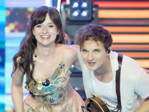 Kto śpiewa Kwiat Jabłoni? To młoda para artystów na scenie, ona w ozdobnej sukni, on z gitarą.