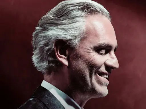 Uśmiechnięty Andrea Bocelli w garniturze. Zastanawiasz się, ile trwa koncert Andrea Bocelli?