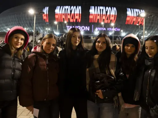 Grupa młodych kobiet czeka na koncert Maty w Krakowie. Na Tauron Arenie świeci napis #MATA2040.