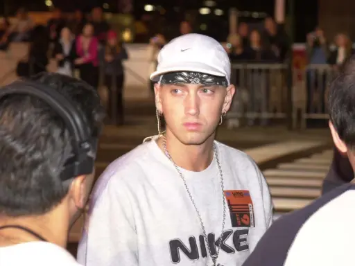 Eminem w białej czapce i z łańcuchami na szyi. Zastanawiasz się, ile Eminem ma piosenek?