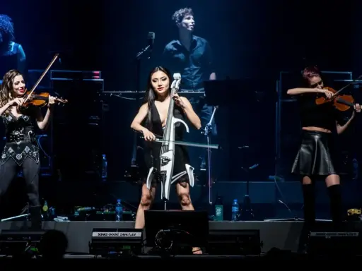 Trzy artystki grają na instrumentach smyczkowych podczas koncertu. Zastanawiasz się, ile trwa koncert Hansa Zimmera?