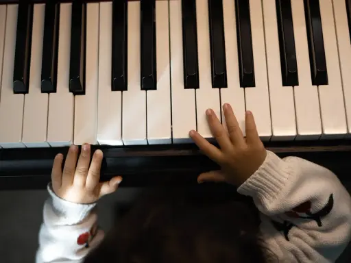 Małe rączki na klawiaturze pianina, jakby szukały melodii, która tworzy teksty piosenek które dają do myślenia.