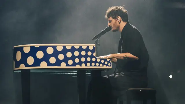Dawid Podsiadło gra na pianinie w kropki. Zastanawiasz się, ile trwa koncert Dawida Podsiadło?