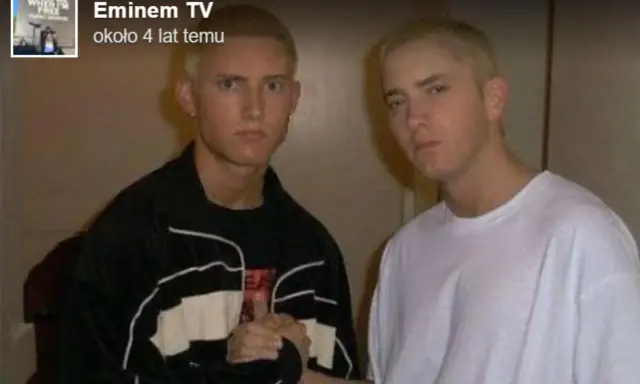 Dwóch młodych mężczyzn, jeden w czarnej bluzie, drugi w białej koszulce, pozuje do zdjęcia. Czy eminem żyje? Tak, ten artysta ma się dobrze.