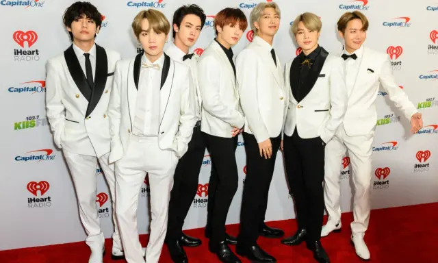 Siedmiu członków BTS w białych garniturach na czerwonym dywanie. Zastanawiasz się, ile kosztuje bilet na koncert BTS?