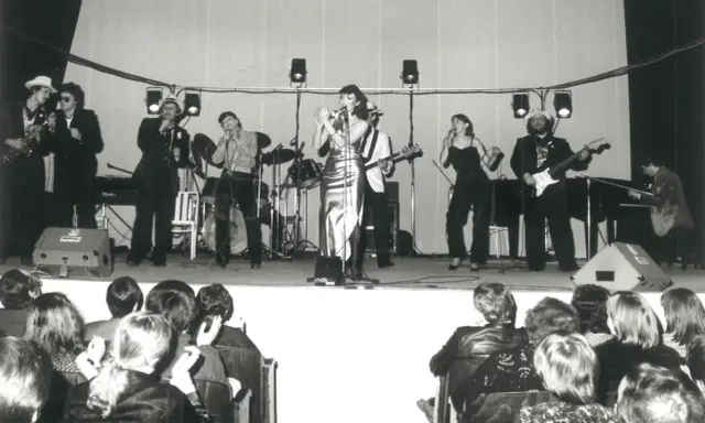 Zespół muzyczny na scenie, w tym wokalistki i gitarzyści. Kto śpiewał kawiarenki? To oni!