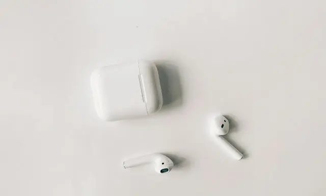 Białe słuchawki AirPods i etui na białym tle. Czy airpods działają z androidem? Tak, można je sparować.