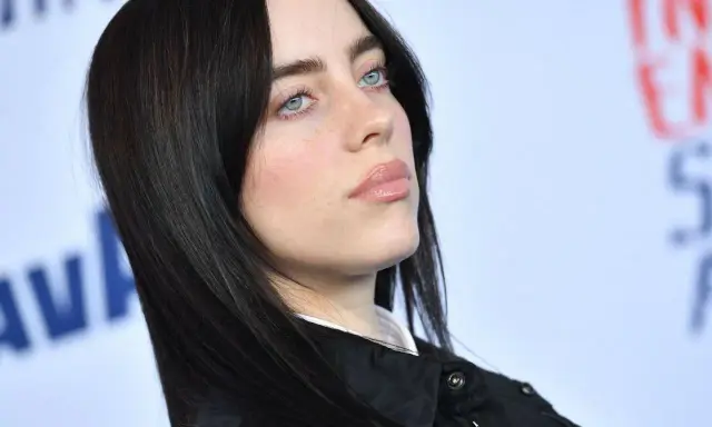 Billie Eilish z błękitnymi oczami i czarnymi włosami. Zastanawiasz się, ile kosztuje bilet na koncert Billie Eilish?