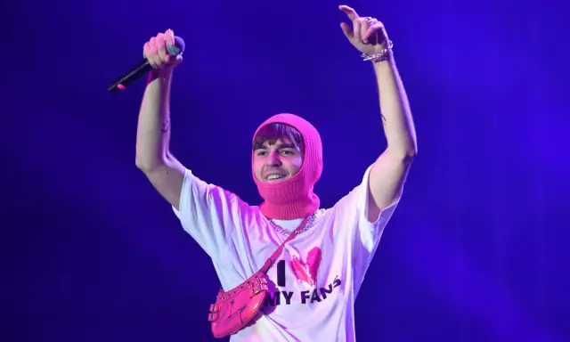 Mata z mikrofonem i różową kominiarką na głowie, w koszulce "I ❤️ MY FANS". Fani zastanawiają się, ile trwają koncerty Maty.