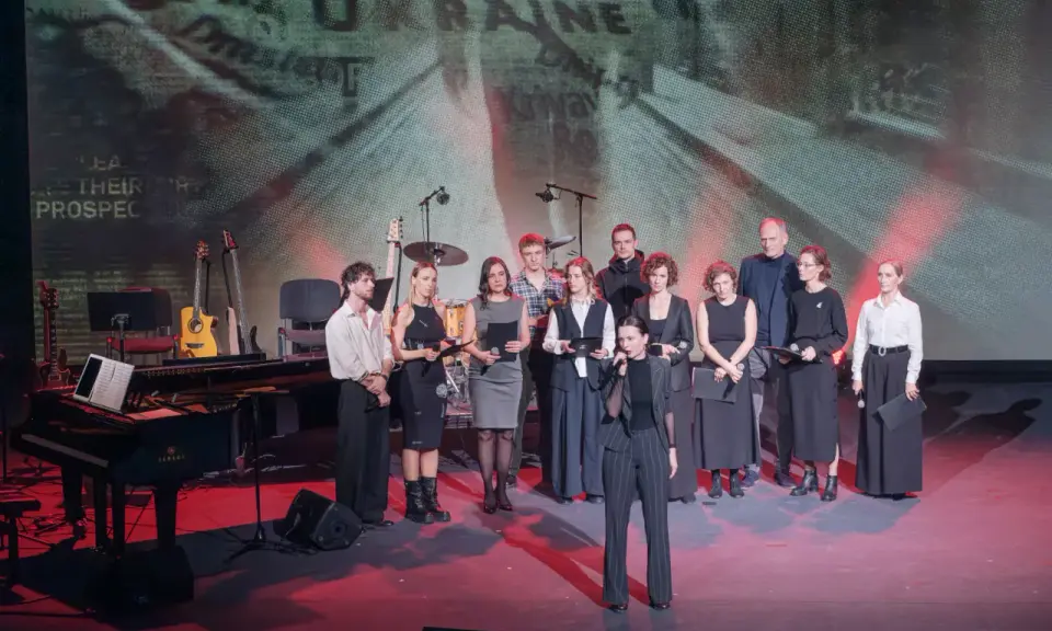 Grupa artystów na scenie, gdzie odbywa się koncert dla Ukrainy. W tle ekran z napisem "UKRAINE".