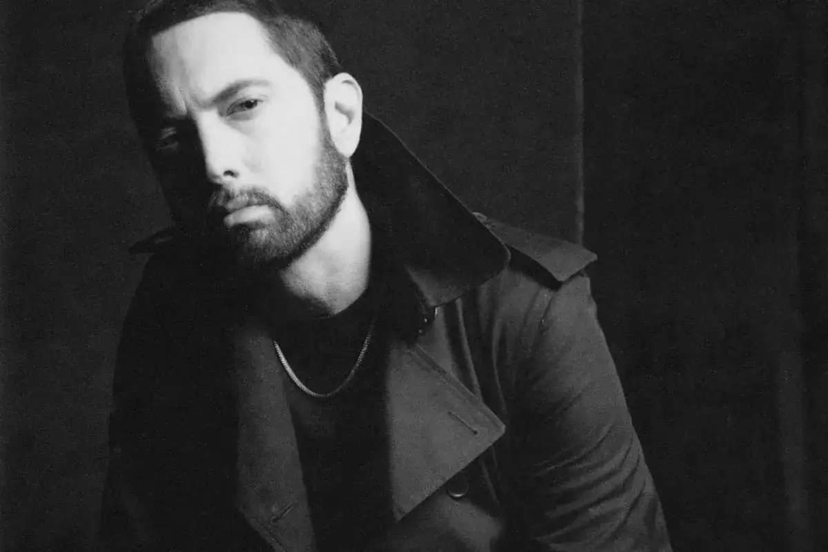 Eminem w czarno-białym kadrze, zamyślony, w płaszczu i z łańcuchem na szyi. Zastanawiasz się, co się dzieje z Eminemem?