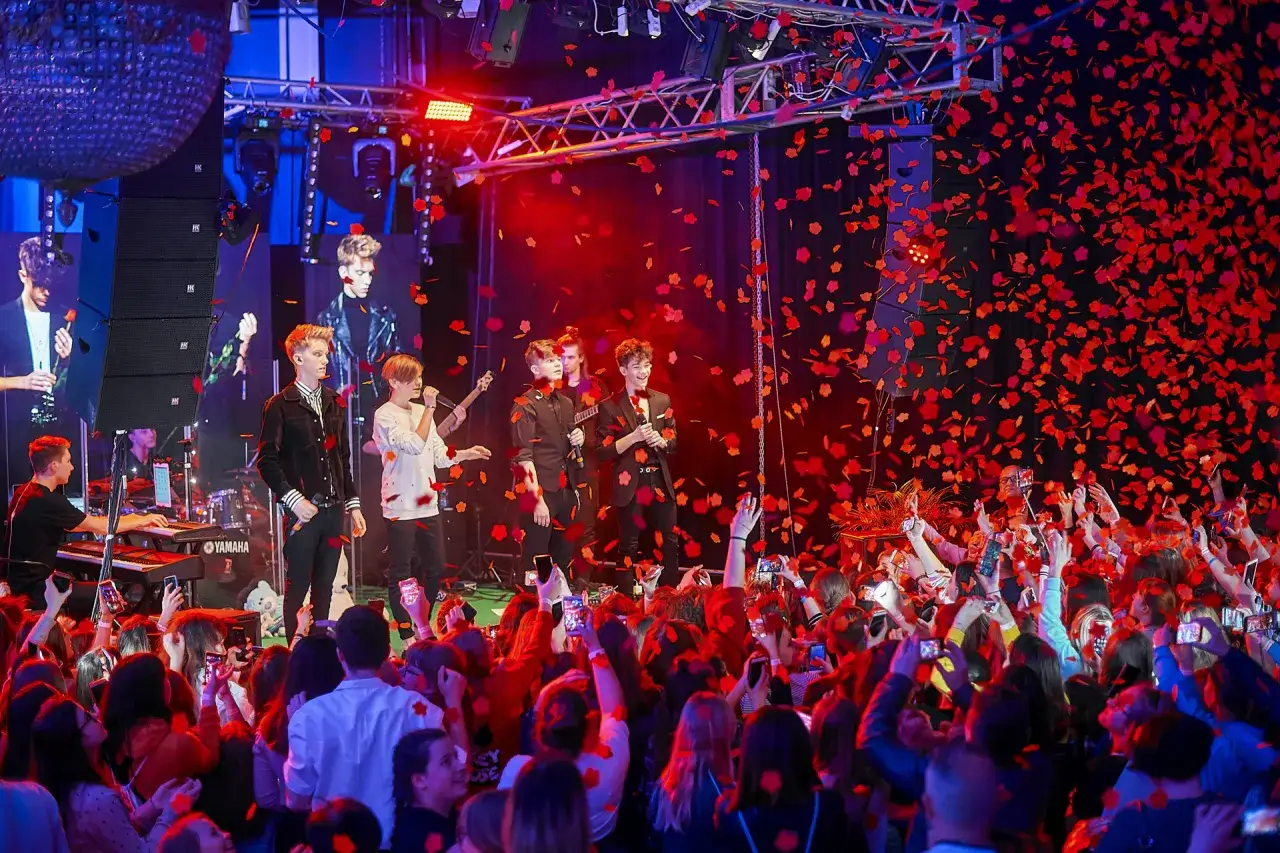 Koncert 4dreamers z opadającymi płatkami. Fani nagrywają występ na telefony.