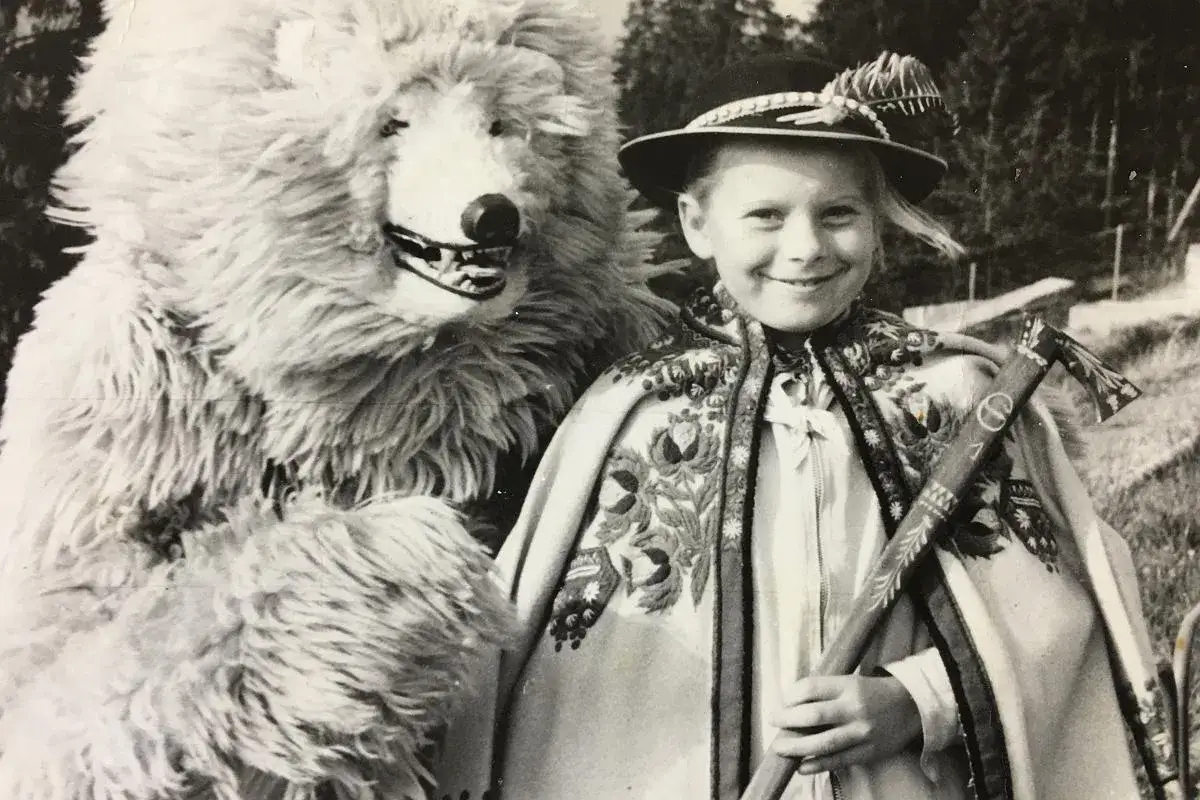 Biały miś w stroju ludowym i dziewczynka z ciupagą, gotowi do wspólnego śpiewania.