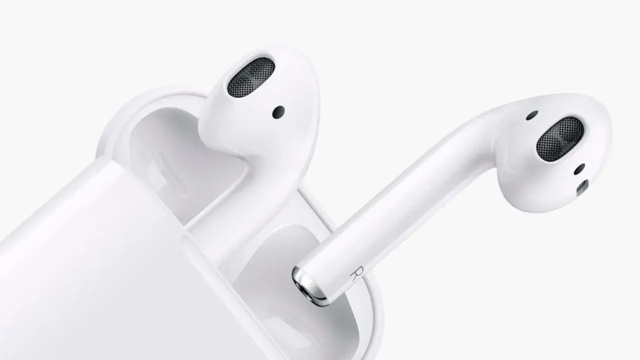 Białe słuchawki AirPods z etui. Dowiedz się, jak sprawdzić ile AirPods mają baterii, by zawsze cieszyć się muzyką.