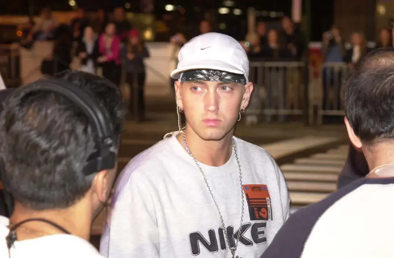 Eminem w białej czapce i bandanie, z łańcuchami na szyi, wygląda na zamyślonego. Co się dzieje z Eminemem?