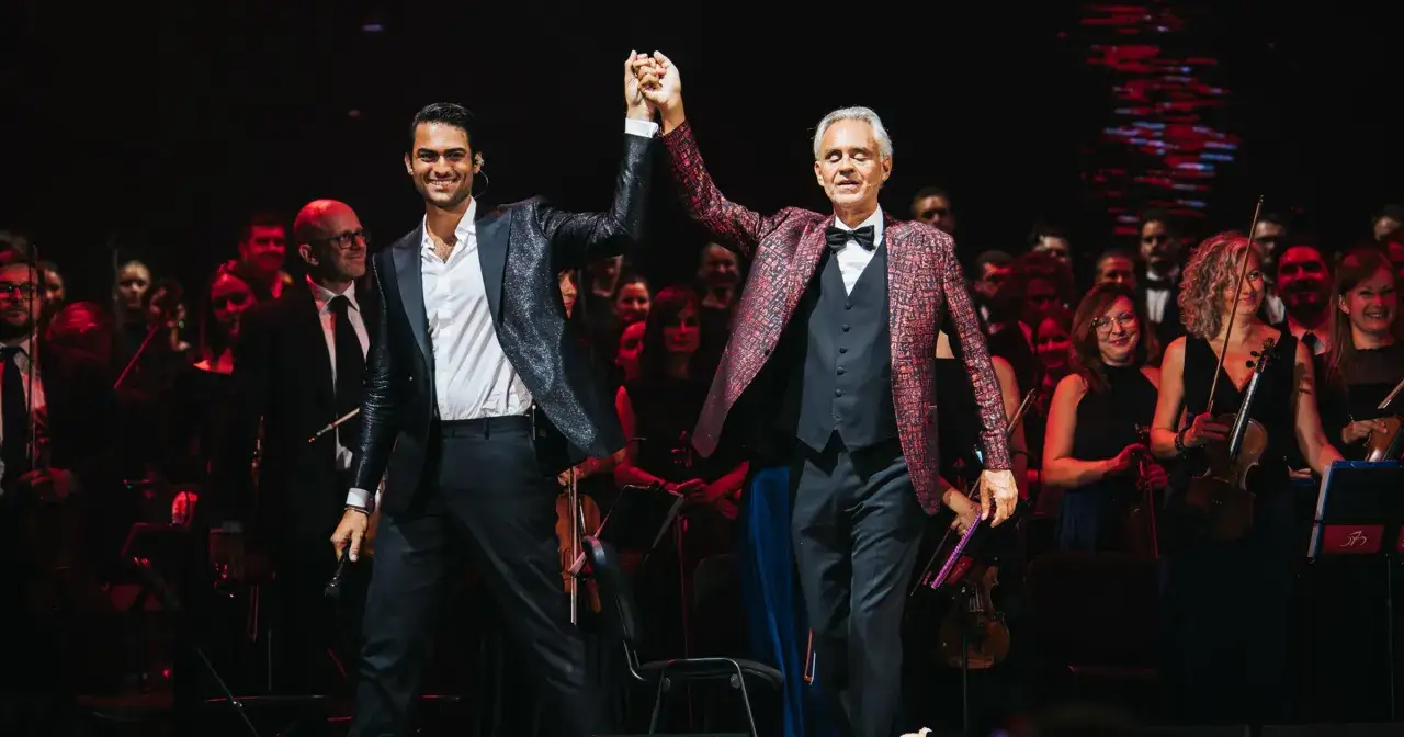 Andrea Bocelli i Matteo Bocelli na scenie, gdzie odbył się koncert Bocellego w Warszawie. Orkiestra i ch&oacute;r w tle.