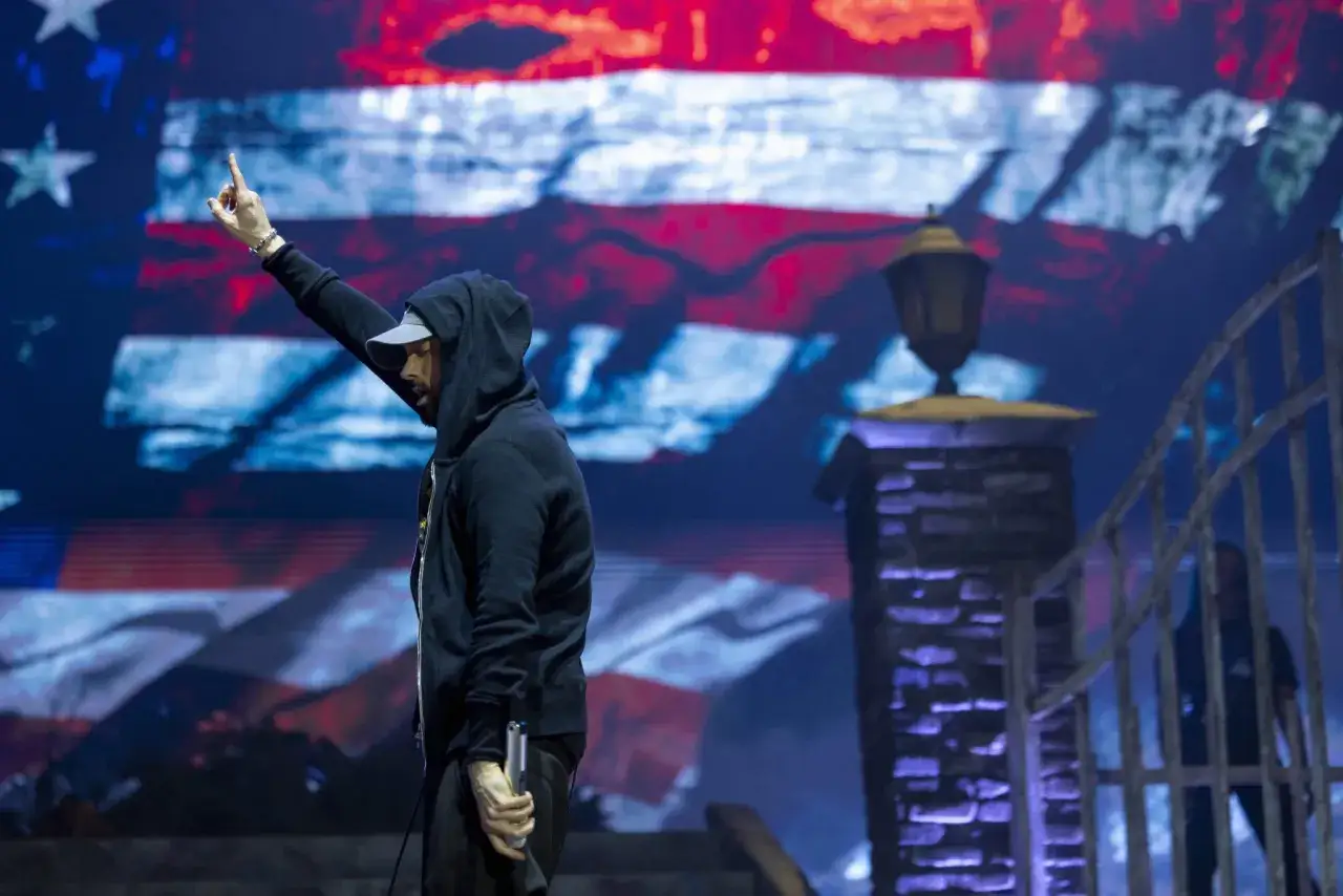 Eminem na koncercie, z palcem w g&oacute;rze, na tle amerykańskiej flagi. Czy Eminem nie lubi Polak&oacute;w? Nie ma dowod&oacute;w na to w jego tw&oacute;rczości.